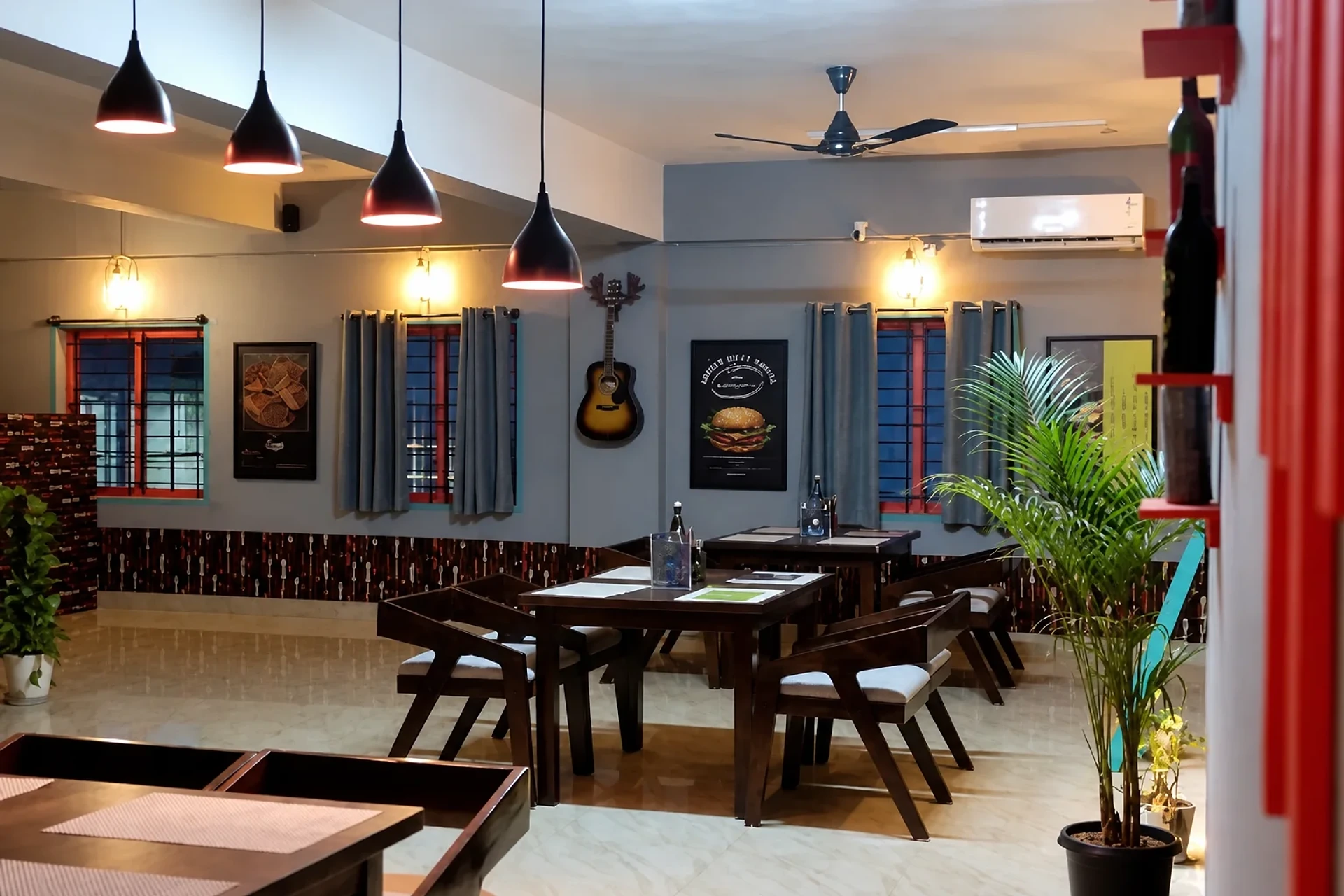 Warm pendant lighting and dining tables at Ninan's JP Nagar