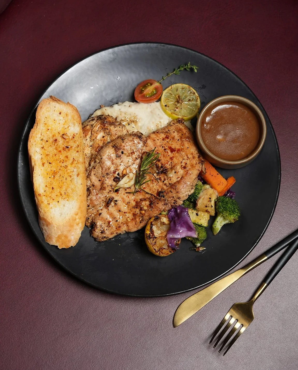 Grilled chicken steak served with vegetables and sauce at Ninan's